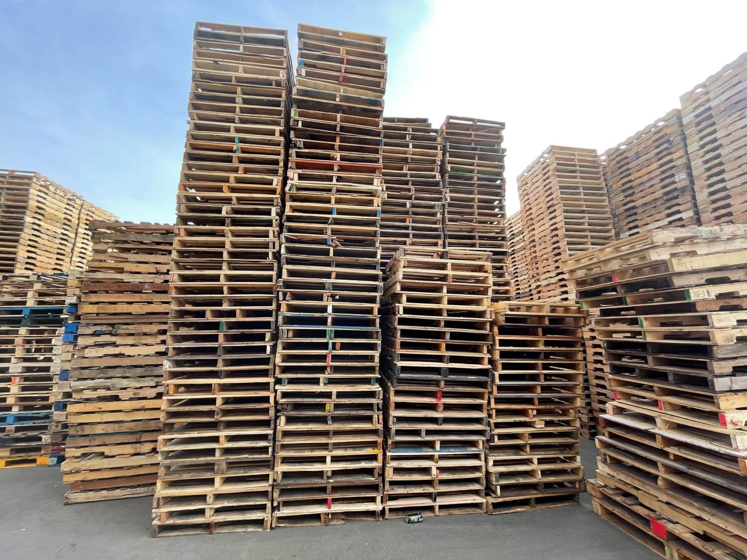 Tall outdoor stacks of recycled wooden pallets at the Pallets Pallets Pallets Atlanta yard